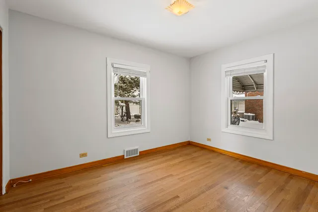 an empty room with wooden floor and a window