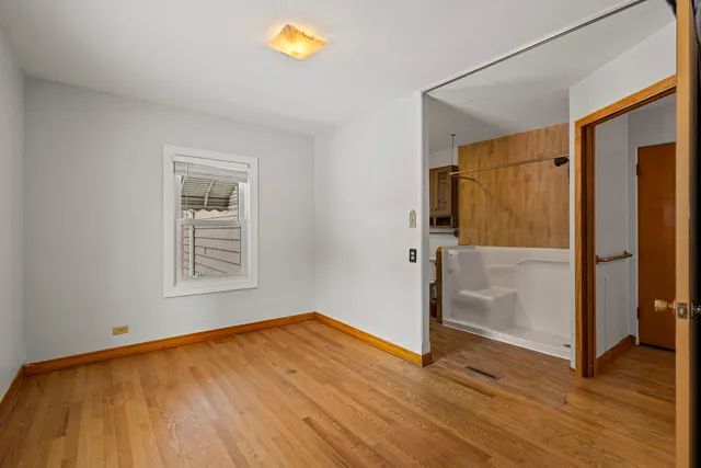 a view of a room with wooden floor and a window