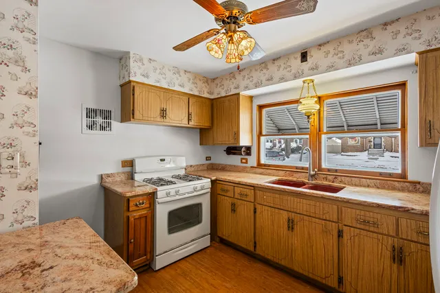 a kitchen with stainless steel appliances a refrigerator a sink and white cabinets