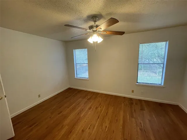 a view of a livingroom with wooden floor and a ceiling fan