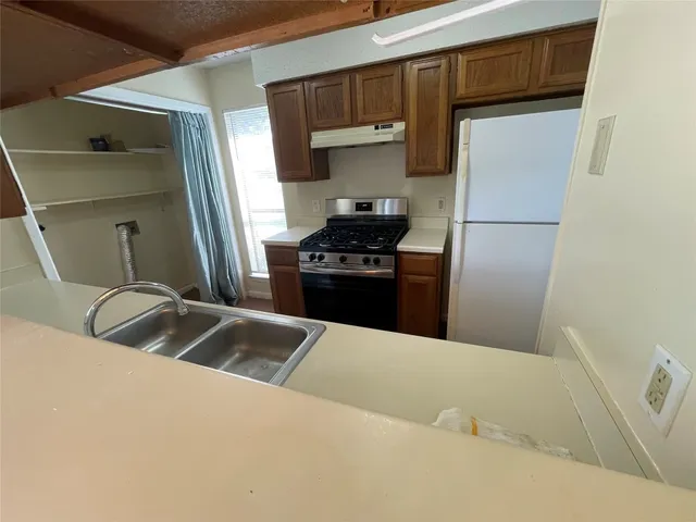 a kitchen with stainless steel appliances granite countertop a sink and a refrigerator
