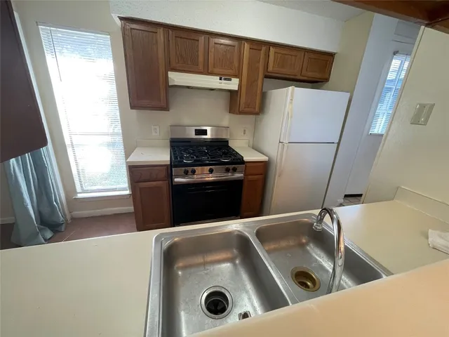 a kitchen with a stove sink and a refrigerator