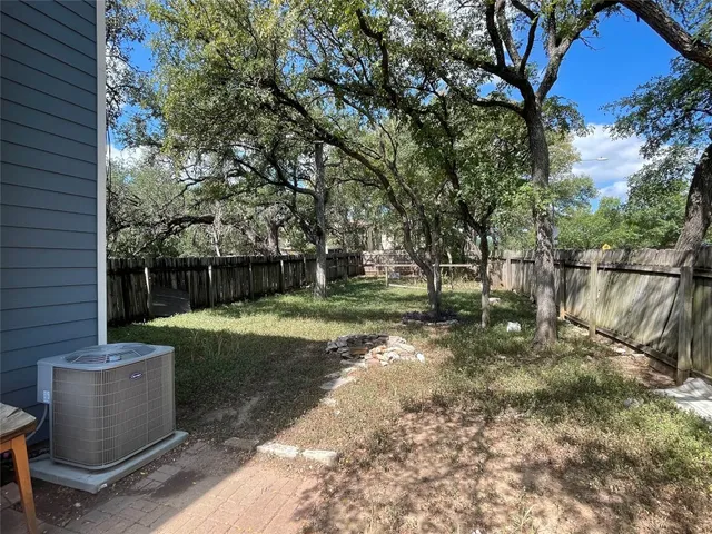 a view of a yard in front of a house with large tree