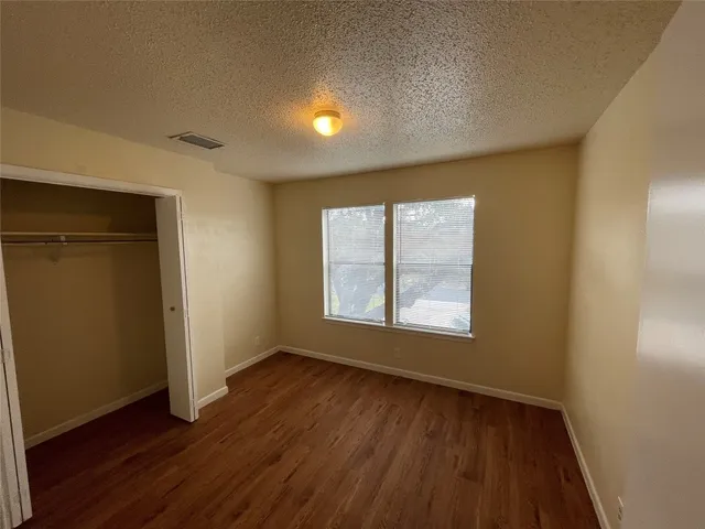 a bathroom with a granite countertop toilet sink and mirror