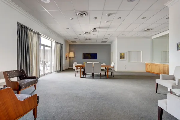 a living room with furniture a rug kitchen view and a large window