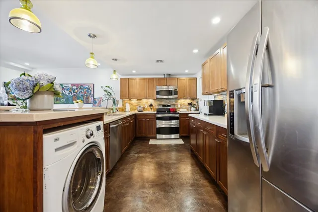 a large kitchen with stainless steel appliances lots of counter top space