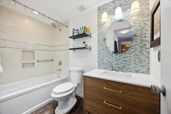 a bathroom with a sink a toilet and shower