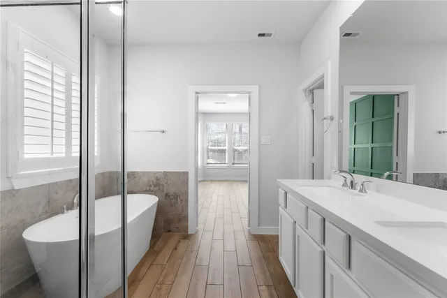 a bathroom with a tub sink and mirror