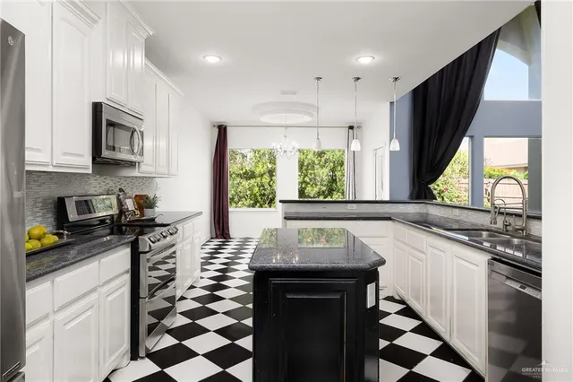 a kitchen with stainless steel appliances a sink stove and cabinets