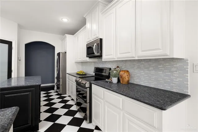 a kitchen with stainless steel appliances granite countertop a sink stove and cabinets