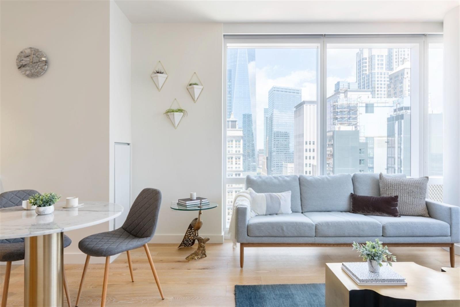 19 Dutch Street, Unit 18B Manhattan, NY 10038 - Photo 2 of 22 a living room with furniture and a large window