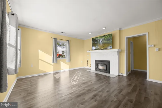 a view of a livingroom with a fireplace wooden floor and window
