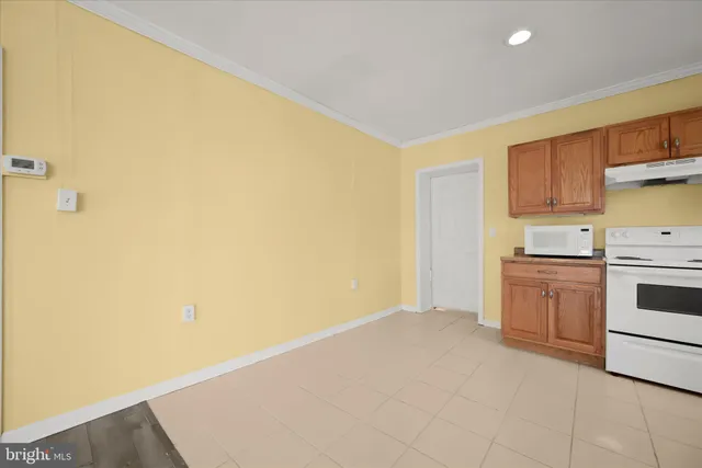 a view of a kitchen with white cabinets and wooden floor