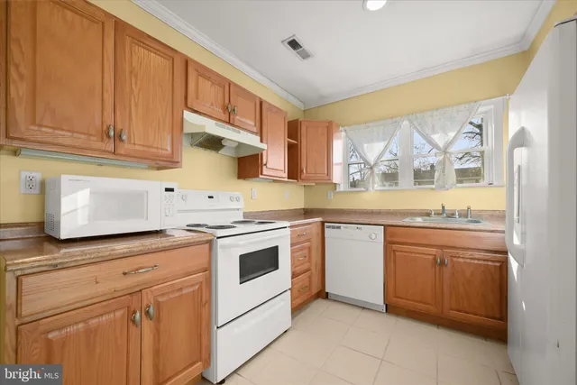 a kitchen with granite countertop white cabinets and white appliances
