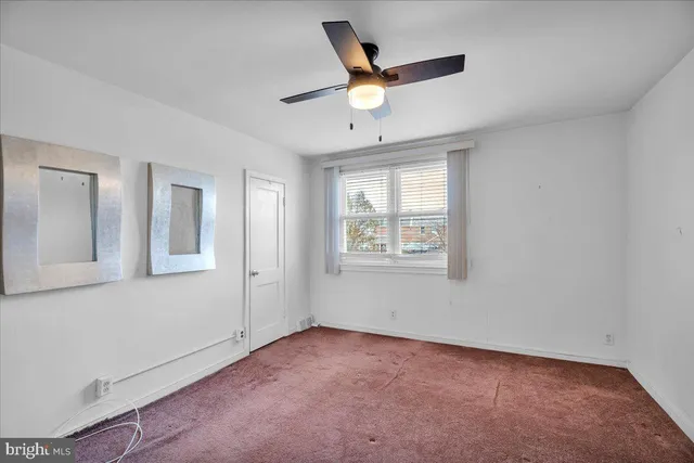 a view of an empty room with a ceiling fan