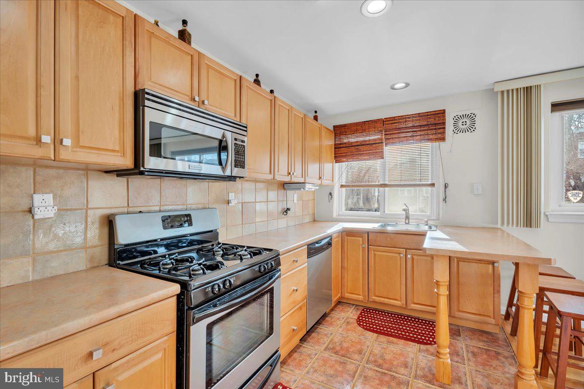 8504 Forrest Avenue Philadelphia, PA 19150 - Photo 10 of 23 a kitchen with stainless steel appliances granite countertop a stove a sink and a microwave
