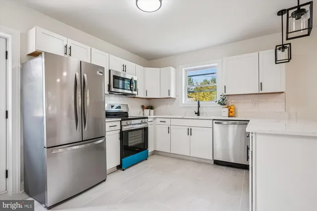 a kitchen with stainless steel appliances granite countertop a refrigerator sink and stove