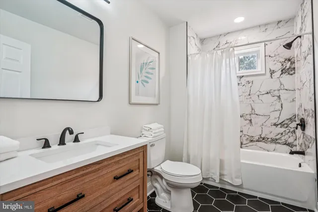 a bathroom with a sink a toilet and bathtub
