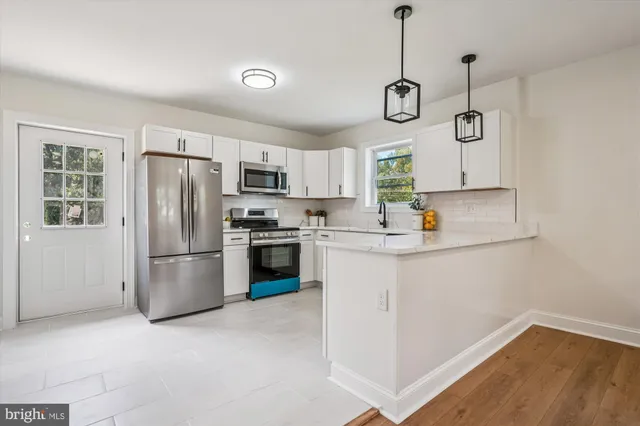 a kitchen with a refrigerator a microwave and a stove top oven