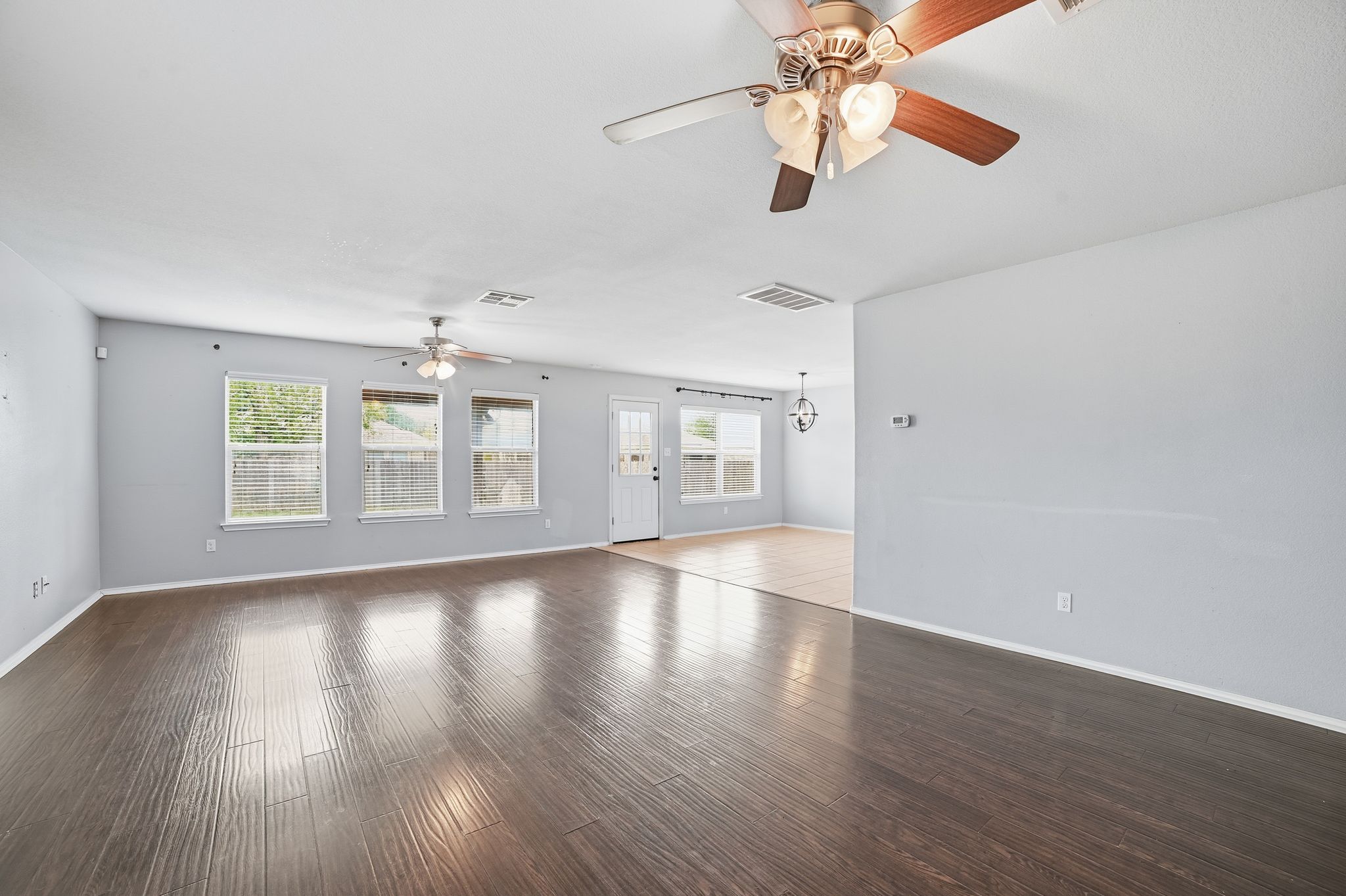316 Housefinch Loop Leander, TX 78641 - Photo 13 of 37 a view of an empty room with window and wooden floor