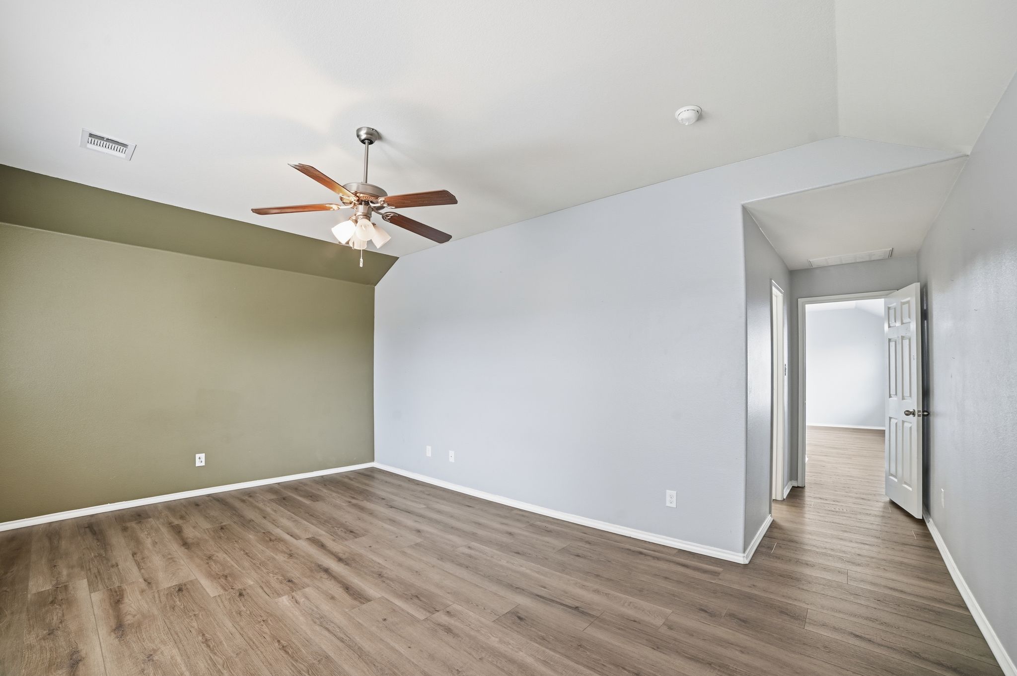 316 Housefinch Loop Leander, TX 78641 - Photo 23 of 37 Primary Bedroom #1 - Owner's suite with accent wall and ceiling fan.