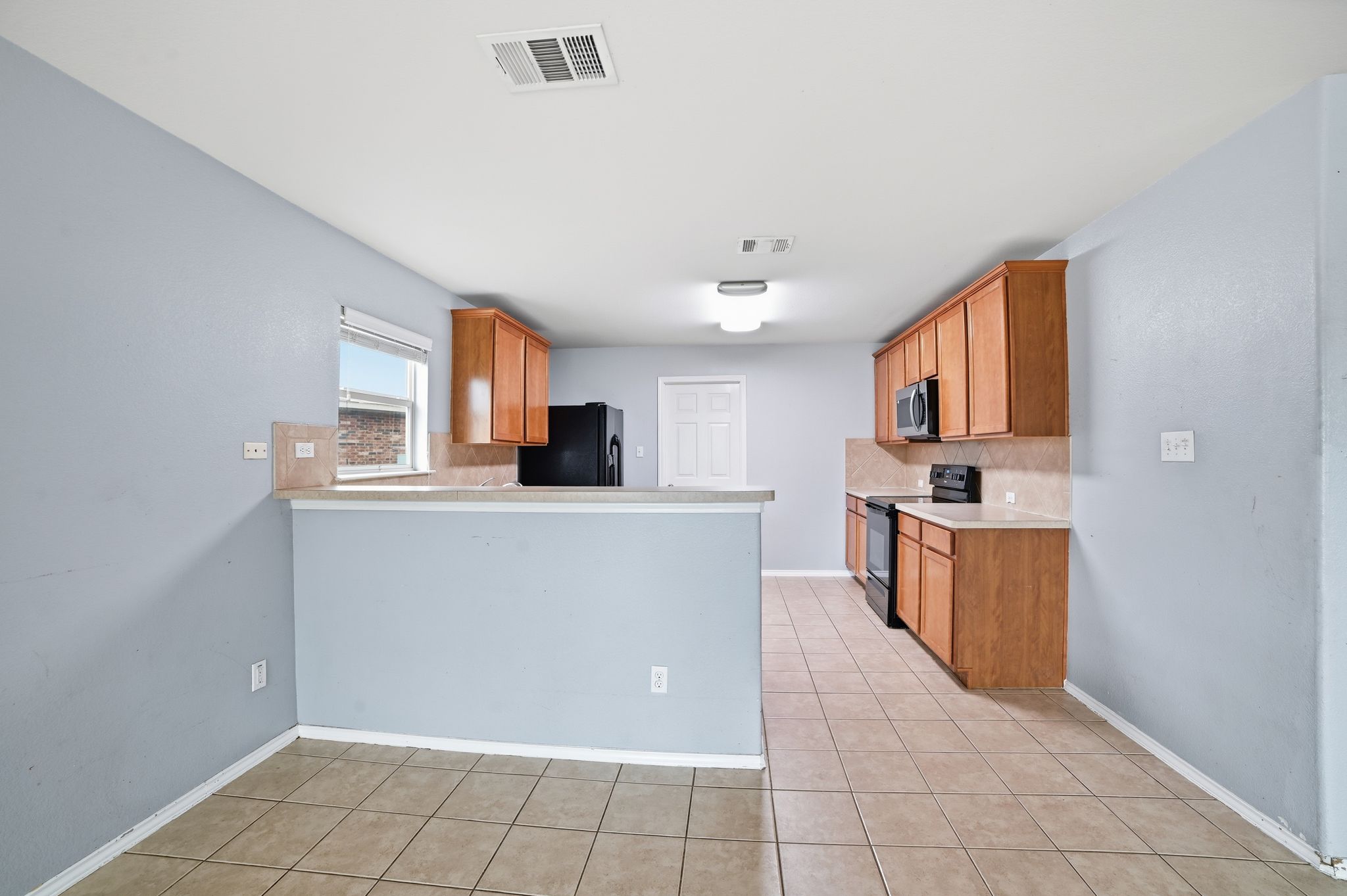 316 Housefinch Loop Leander, TX 78641 - Photo 10 of 37 Open-concept layout connecting kitchen and living areas.