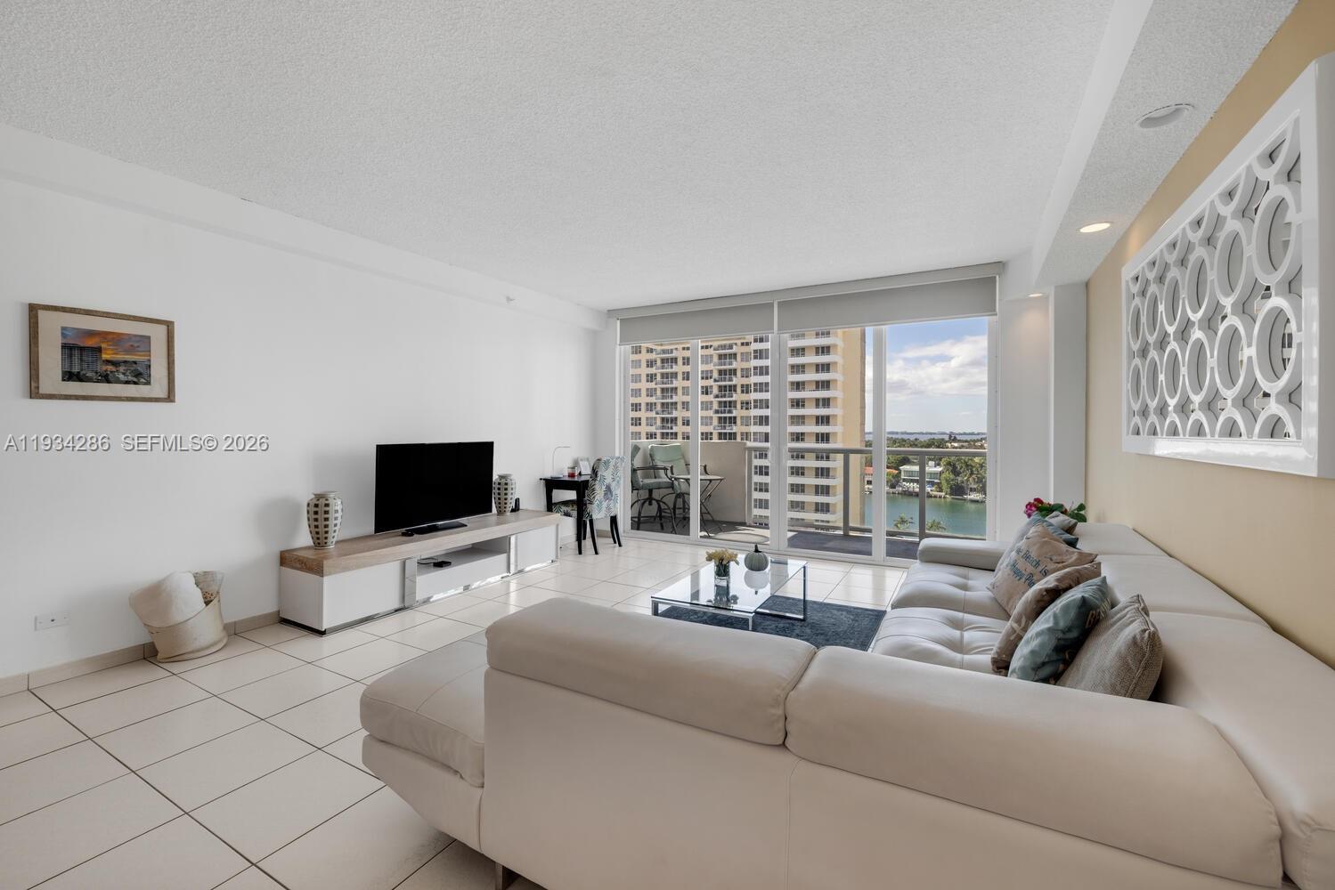5601 Collins Avenue, Unit 1019 Miami Beach, FL 33140 - Photo 18 of 29 a living room with furniture and a flat screen tv