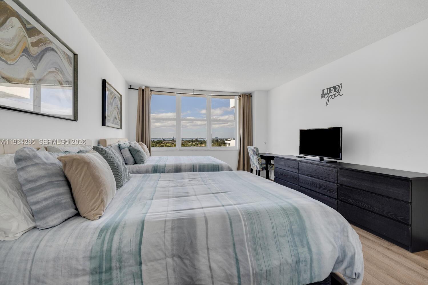 5601 Collins Avenue, Unit 1019 Miami Beach, FL 33140 - Photo 25 of 29 a bedroom with a bed and a flat screen tv