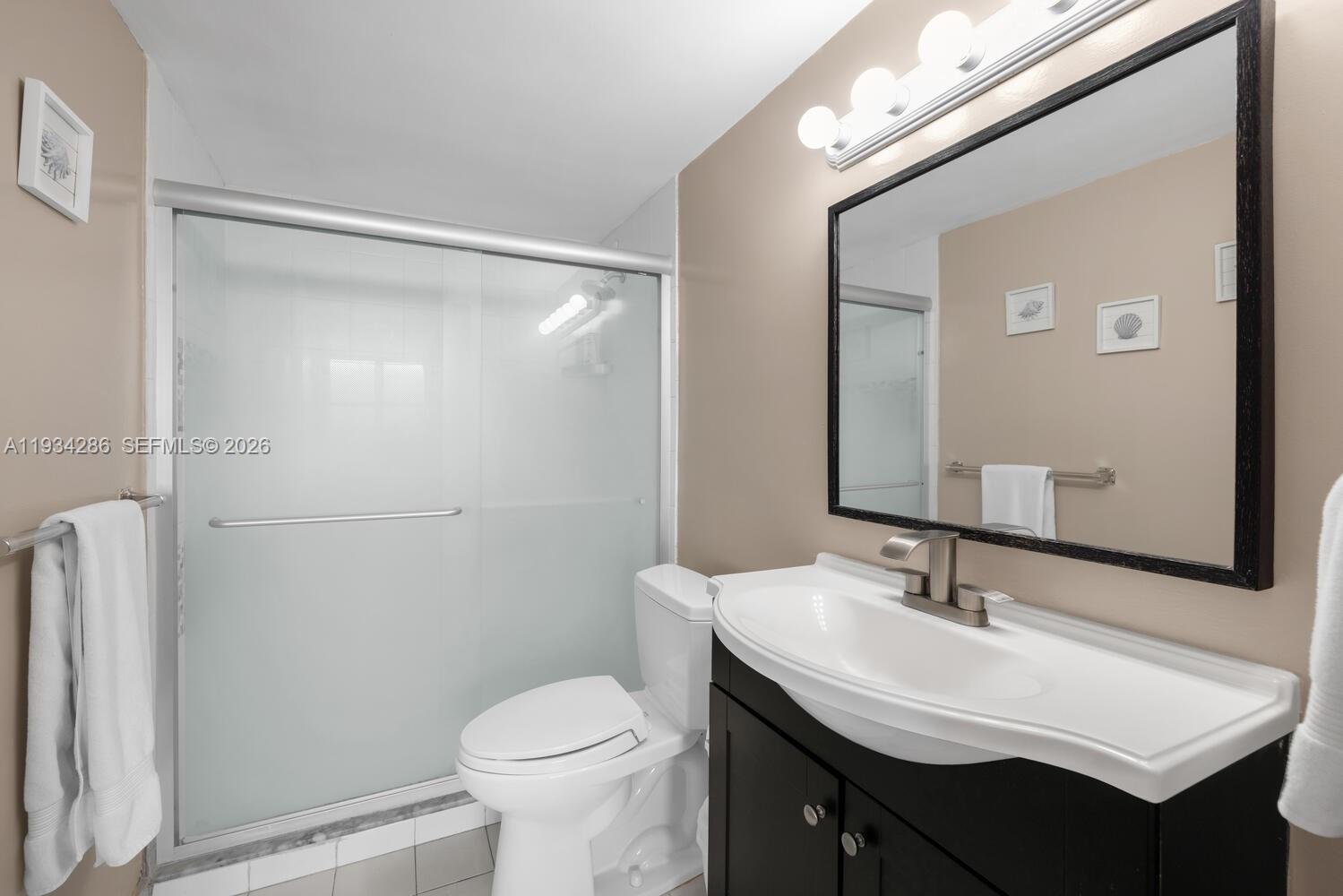 5601 Collins Avenue, Unit 1019 Miami Beach, FL 33140 - Photo 28 of 29 a bathroom with a sink toilet and shower