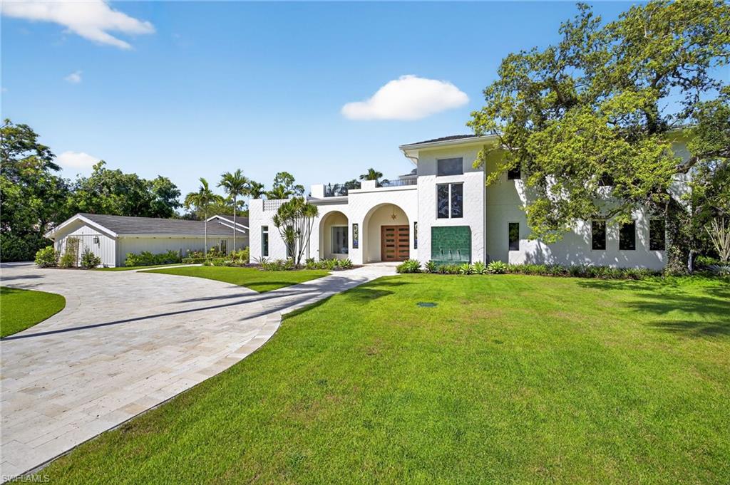 111 Caribbean Road Naples, FL 34108 - Photo 9 of 50 a front view of a house with swimming pool and porch with furniture