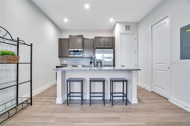 a kitchen with stainless steel appliances granite countertop a stove a sink and a refrigerator