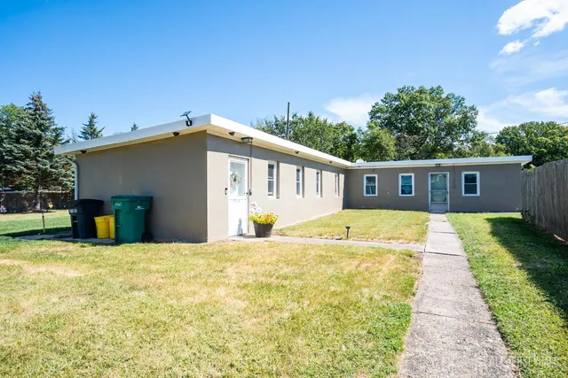 a view of a house with backyard and trees