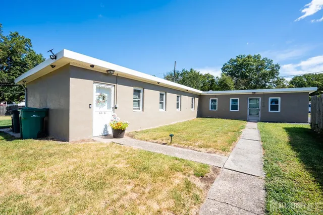 a view of a house with backyard and trees