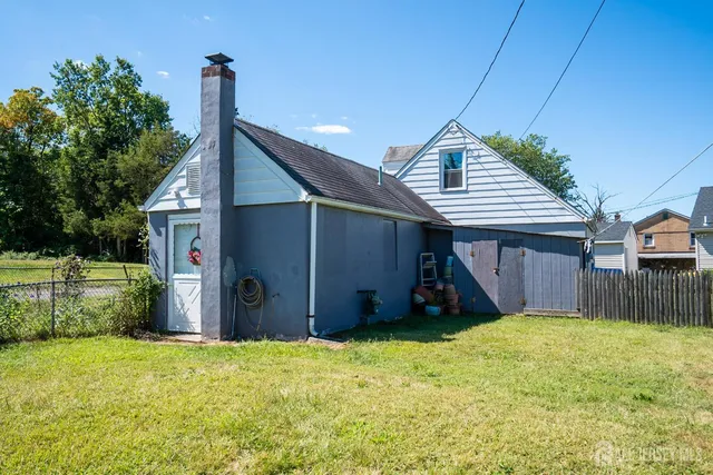 a view of a house next to a big yard and large tree