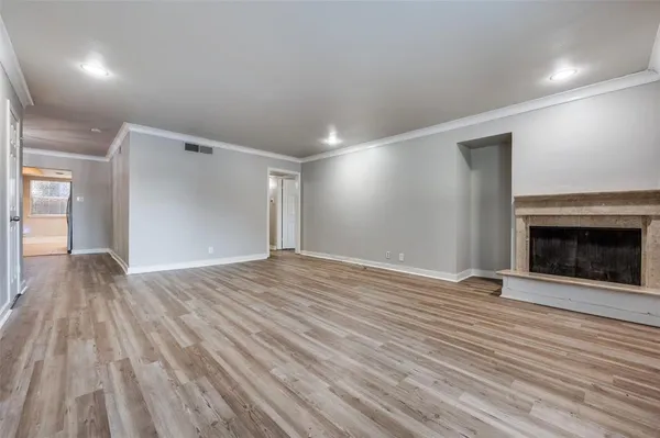an empty room with wooden floor and fireplace
