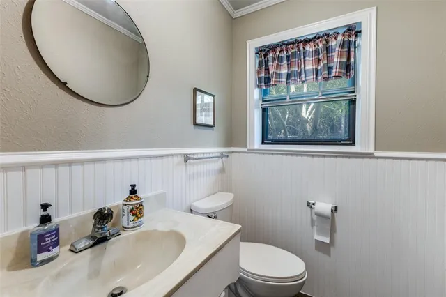 a bathroom with a toilet a sink and mirror