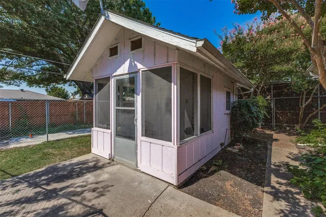 a view of a small house with wooden fence