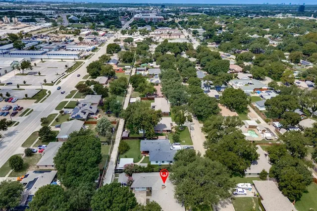 an aerial view of residential houses with outdoor space and trees