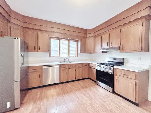 a kitchen with granite countertop white cabinets and white appliances