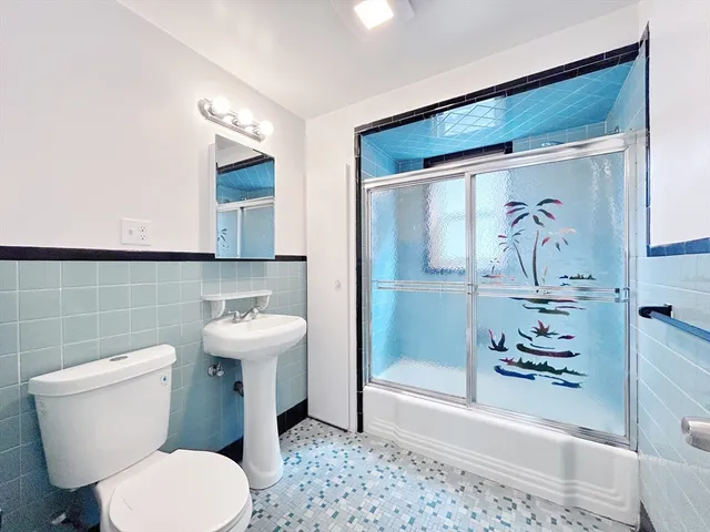 a white toilet sitting next to a bathroom sink
