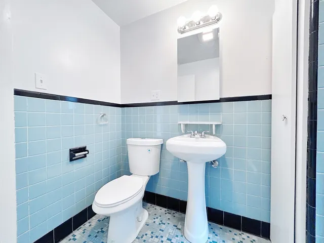 a bathroom with a sink a toilet and a mirror