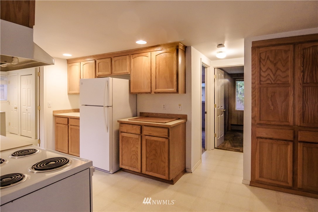 22028 9th Avenue Southeast Bothell, WA 98021 - Photo 11 of 16 a kitchen with refrigerator a stove a sink and cabinets