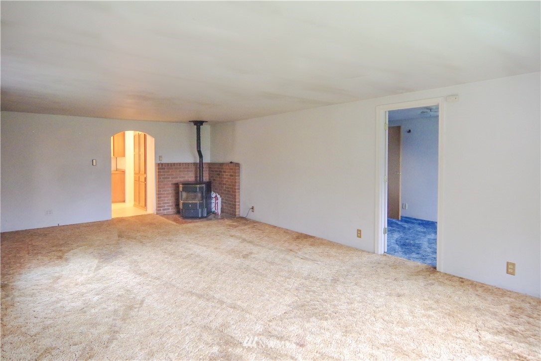 22028 9th Avenue Southeast Bothell, WA 98021 - Photo 6 of 16 an empty room with a fireplace and windows
