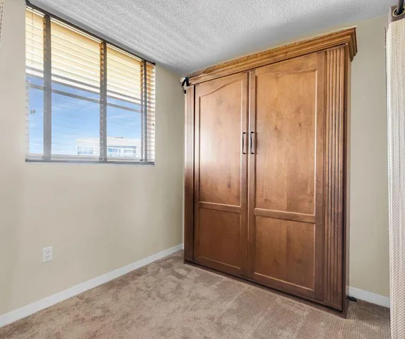 an empty room with windows and closet