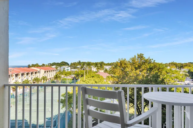 a view of a balcony with wooden chairs
