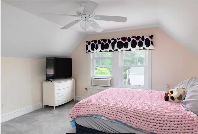 a bedroom with a bed and a flat tv screen on the dresser