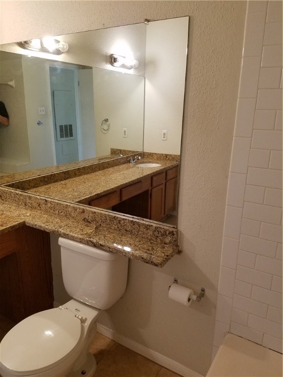 2450 Wickersham Lane, Unit 1317 Austin, TX 78741 - Photo 13 of 20 a bathroom with a granite countertop toilet sink and mirror