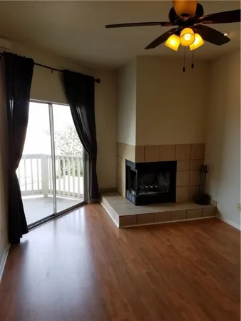 an empty room with wooden floor and fireplace