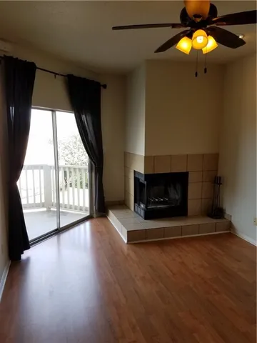 an empty room with wooden floor and fireplace