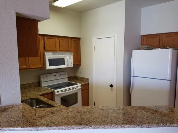 a kitchen with a refrigerator and a stove top oven